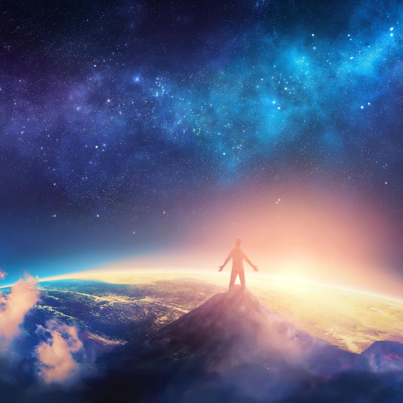 CG Image of Person on Top of Mountain, looking down at Earth with Space in the Background